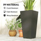Tall black plastic planter with crack-resistant textured finish and green plant