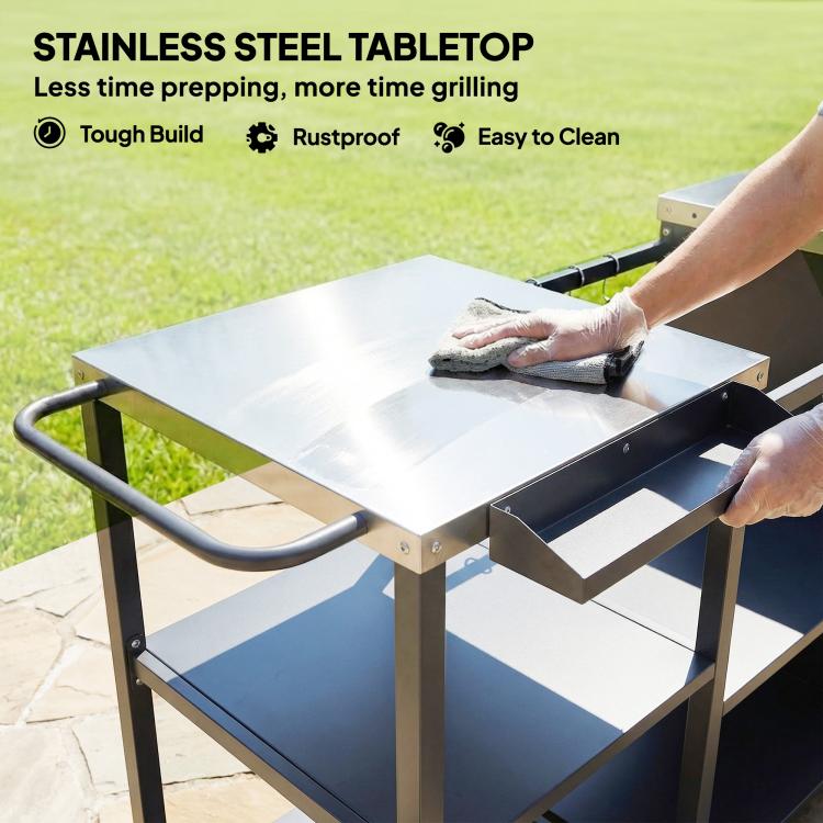 Stainless steel tabletop on black BBQ prep table with side shelf and storage cabinet