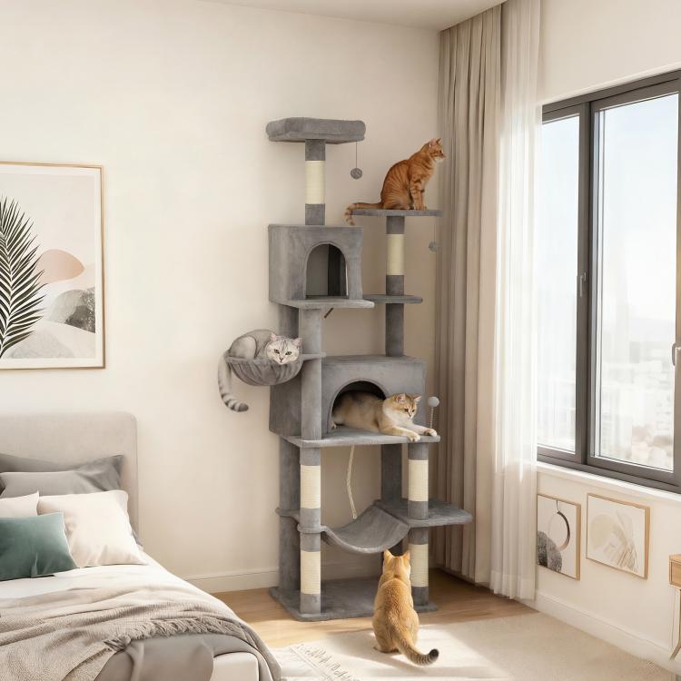 Dark gray cat tower beside a window with multiple platforms and two enclosed condos