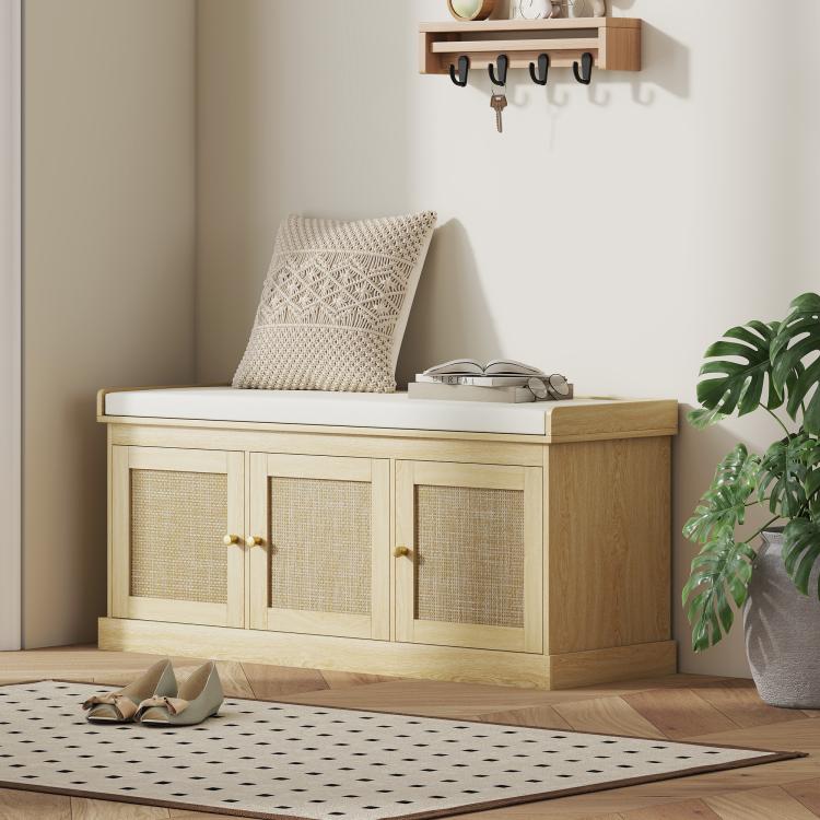 Light oak shoe bench with hinged woven rattan doors and cushioned seat, slippers near base