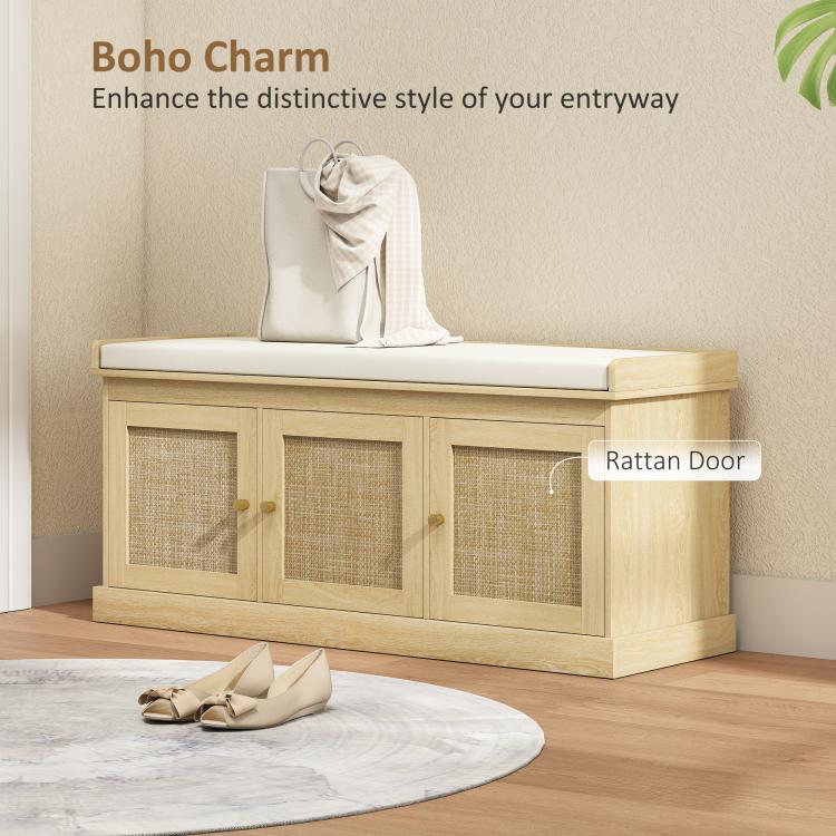 Light oak entryway shoe bench with woven rattan doors and cushioned seat, bag on top