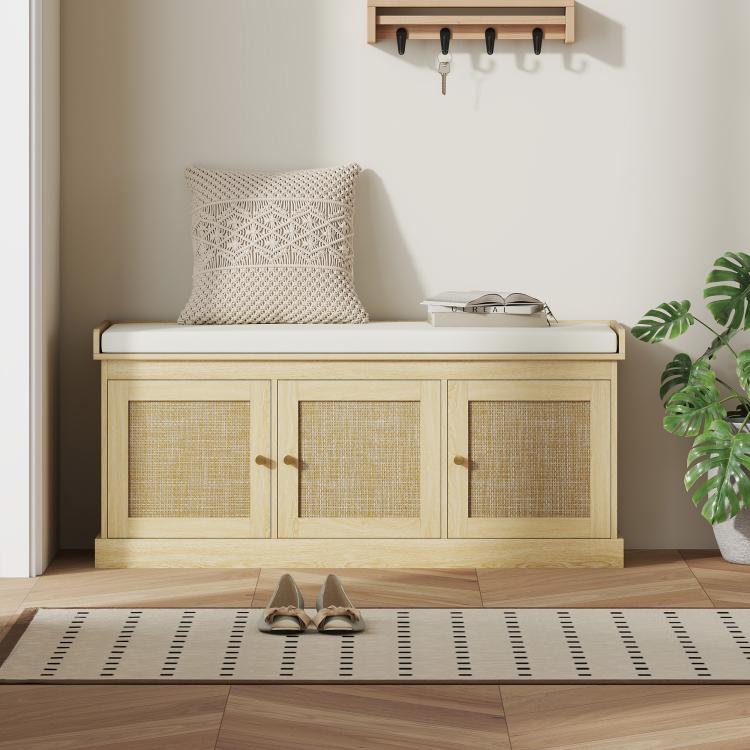 Light oak shoe storage bench with foam-padded cushion, three woven rattan doors, entry rug