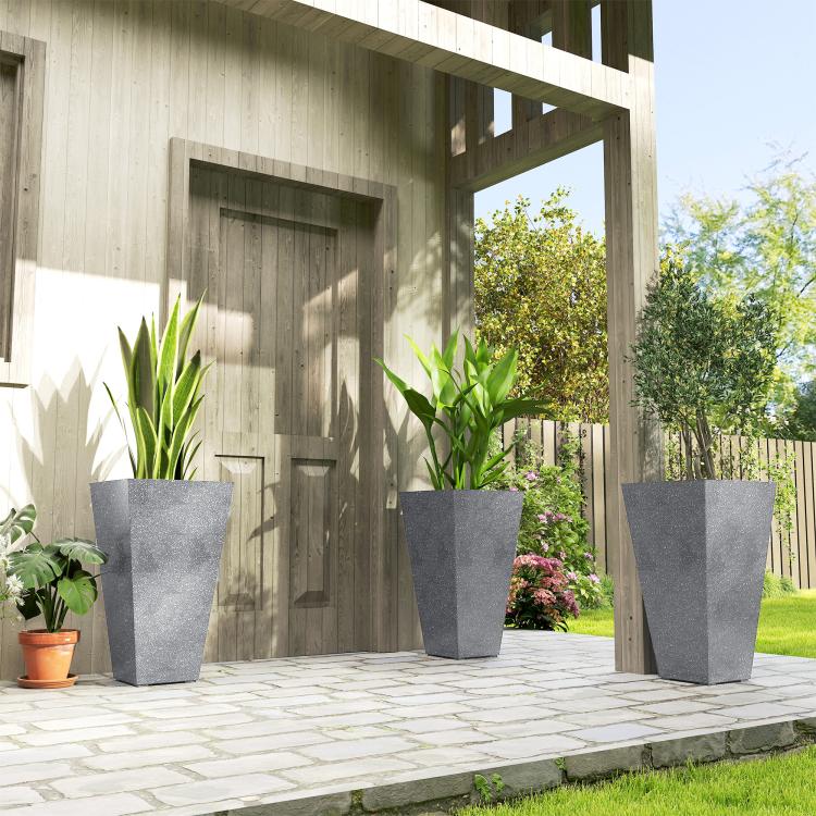 Set of 3 tall gray tapered plastic planters with plants on patio paving