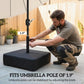 Black umbrella base with pole and adjustable knob, set up on patio