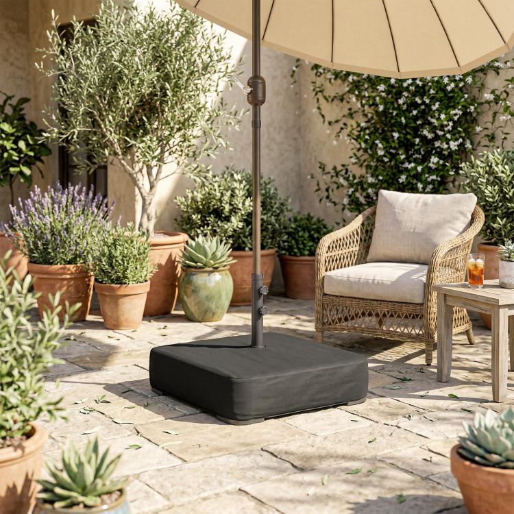 Black umbrella base with square cover on stone patio near outdoor seating