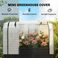 Raised garden bed greenhouse cover with white mesh end panels over flowering plants
