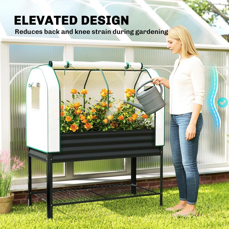 Elevated garden bed with white greenhouse cover; watering can and flowers inside