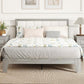 Gray platform bed with tall upholstered headboard and white bedding with pillows