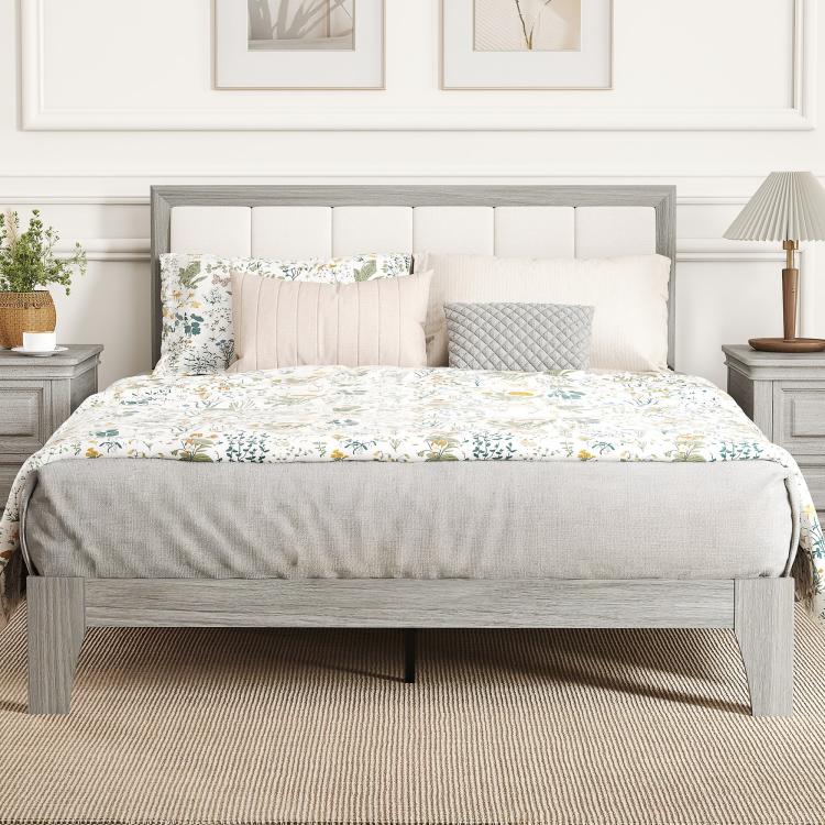 Gray platform bed with tall upholstered headboard and white bedding with pillows