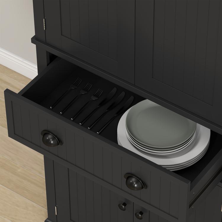 Black kitchen pantry cabinet with central drawer open and plates inside