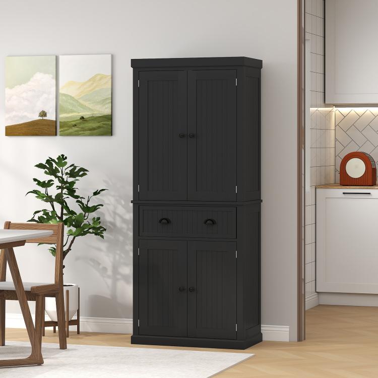 Black kitchen pantry cabinet standing in a room, doors and drawer closed