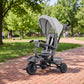 Gray kids tricycle stroller with canopy, front wheels, and three-wheel base
