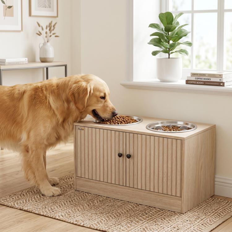 Oak-tone raised dog feeding station with two bowls; golden dog eating