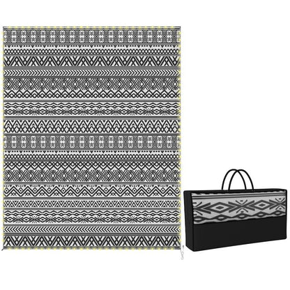 Reversible outdoor rug with black-and-white geometric pattern, with matching carry bag.