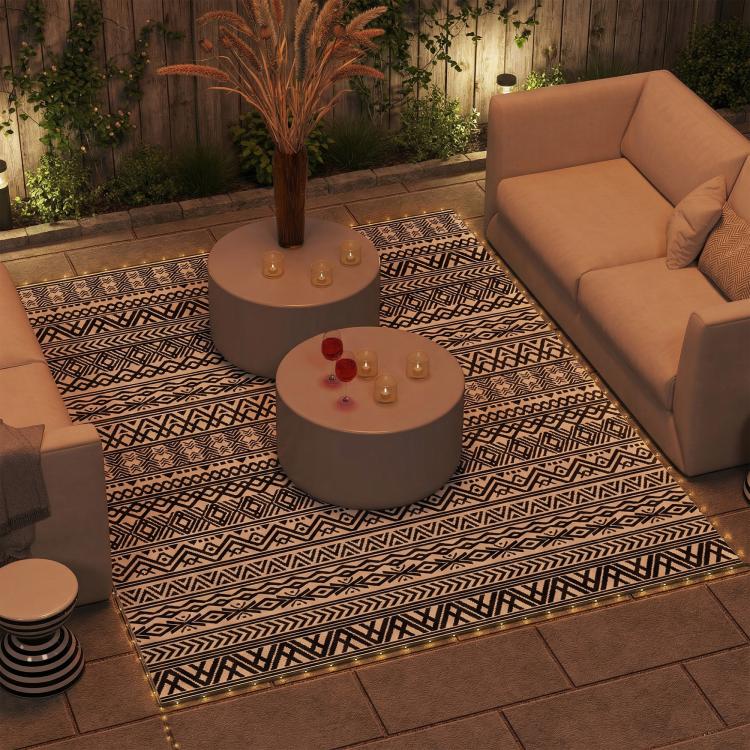 Geometric outdoor area rug with black and white patterned design