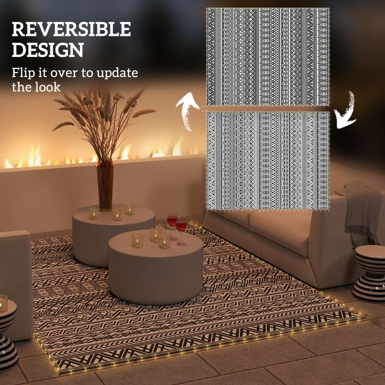 Reversible outdoor rug with black-and-white geometric pattern, shown from both sides.