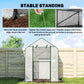 Portable greenhouse with green frame stabilized by ground stakes and guy ropes