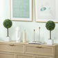 Two small green boxwood topiary balls in white square pots on wooden stems
