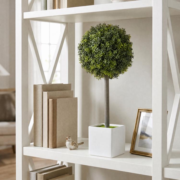 Green artificial boxwood topiary ball in a white square pot on a wooden stem
