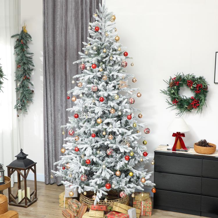 Decorated frosted artificial Christmas tree with red and gold ornaments and star topper