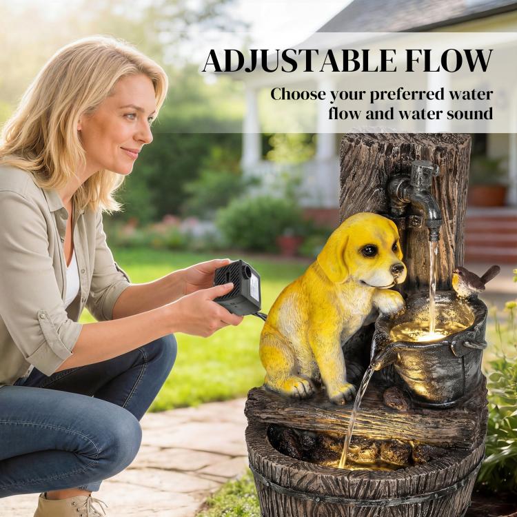 Woman adjusts a device near a dog-themed three-tier resin fountain with flowing water.