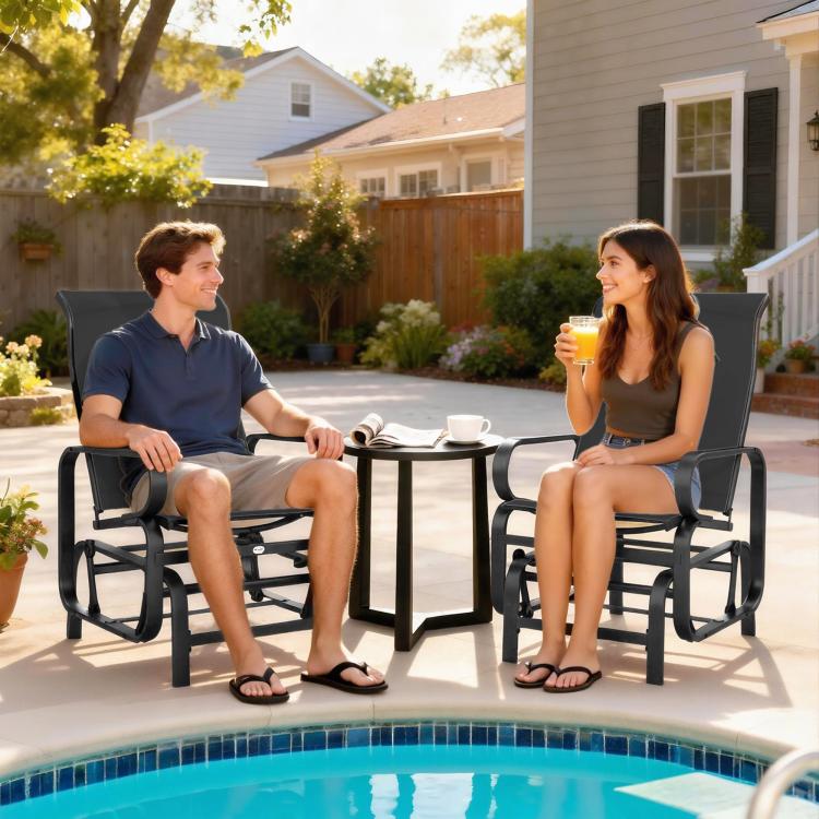 Two black mesh rocking glider chairs with armrests beside outdoor table near pool
