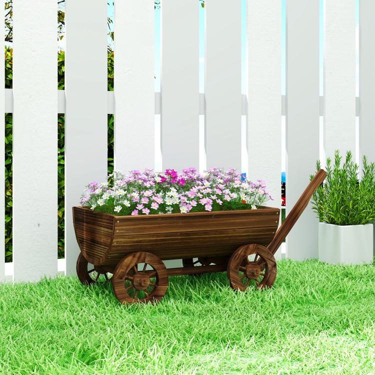 Mobile wooden wagon planter on wheels with flowers, standing on green grass