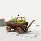 Wooden wagon planter box with flowers and four decorative wheel spokes; handle raised