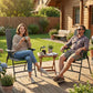 Two people sitting in dark green folding patio chairs with armrests outdoors