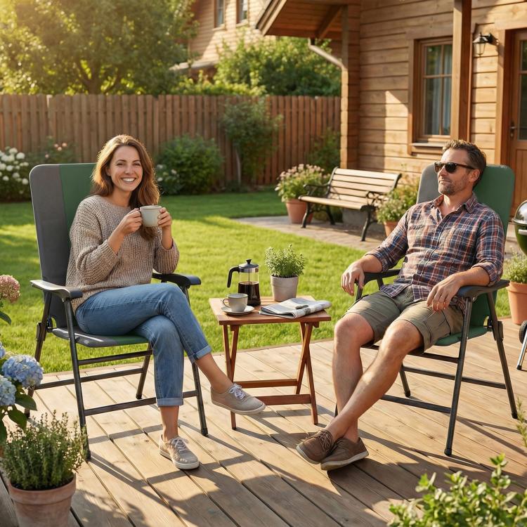 Two people sitting in dark green folding patio chairs with armrests outdoors