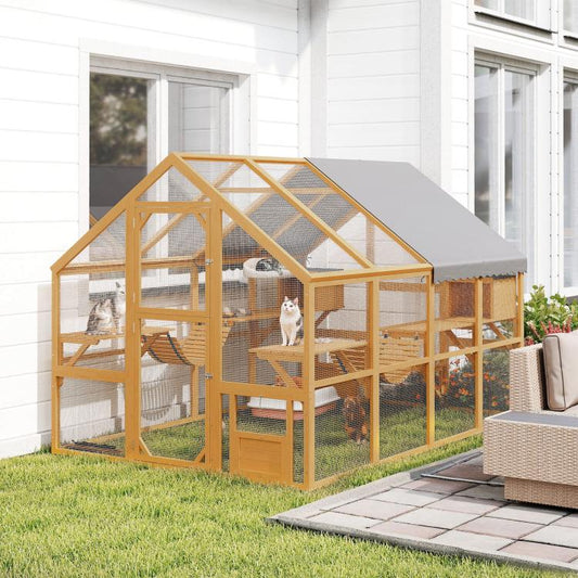 Outdoor wooden cat house with gray canopy, wire mesh enclosure, ramps, and resting areas
