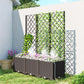 Raised planter bed with trellis panels, potted plants, and watering tubing in yard