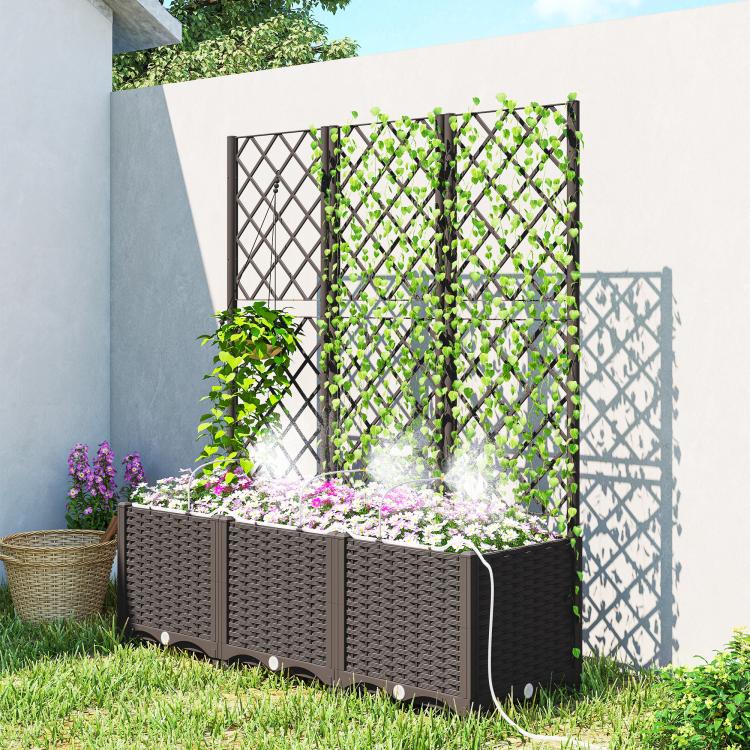 Raised planter bed with trellis panels, potted plants, and watering tubing in yard