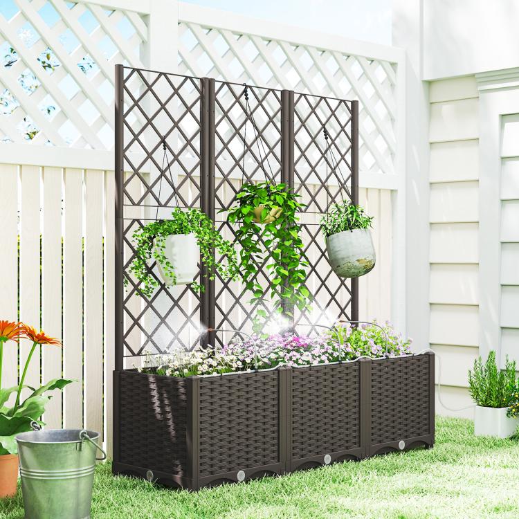 Raised planter bed with dark trellis and hanging planters beside home exterior