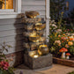 Rustic stone-look tiered jug fountain with cascading water and LED glow