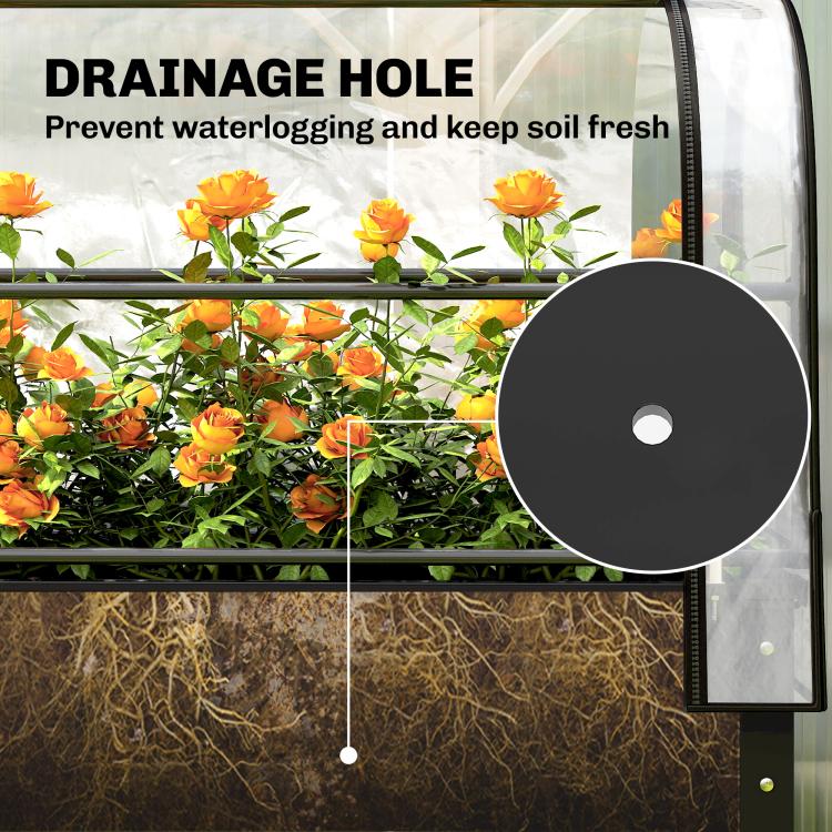 Clear greenhouse cover over raised bed showing drainage hole area and soil below