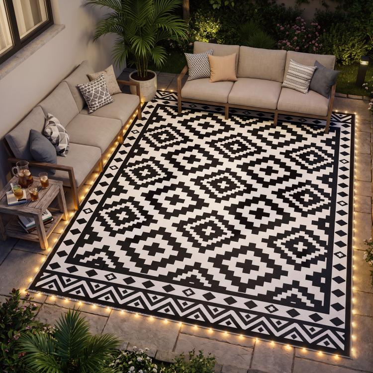 Outdoor reversible rug with black and white geometric pattern and edge LED lights