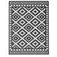 Outdoor reversible rug with black and white geometric diamond pattern