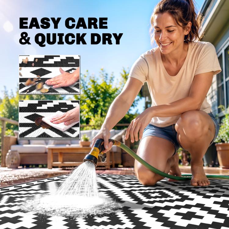 Outdoor black-and-white geometric rug shown being rinsed for quick dry