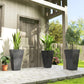 Set of tall black marble-finish planters with plants on outdoor walkway