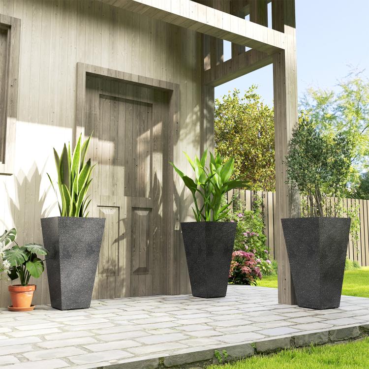 Set of tall black marble-finish planters with plants on outdoor walkway