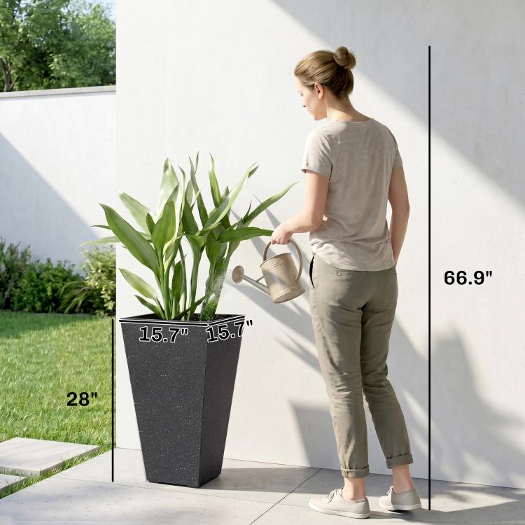 Tall black marble-finish tapered planter next to woman for size scale with green leaves