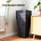 Stackable black marble-finish tapered planters shown stacked in a living room