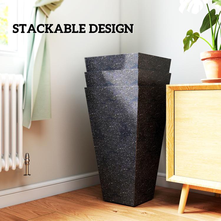 Stackable black marble-finish tapered planters shown stacked in a living room
