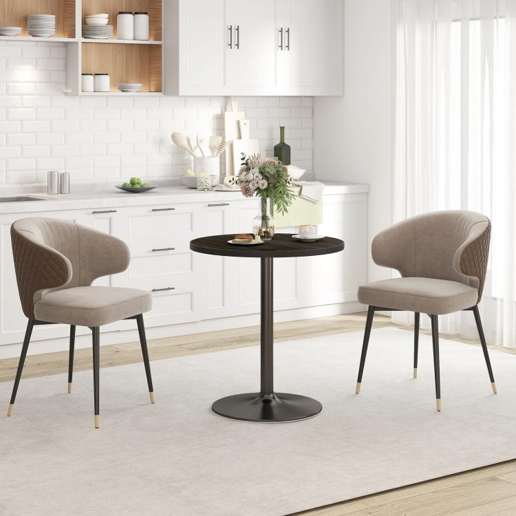 Small round black wood-grain dining table with pedestal base and two beige chairs