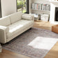 Grey and brown traditional floral area rug with scrolling motifs, centered on hardwood floor