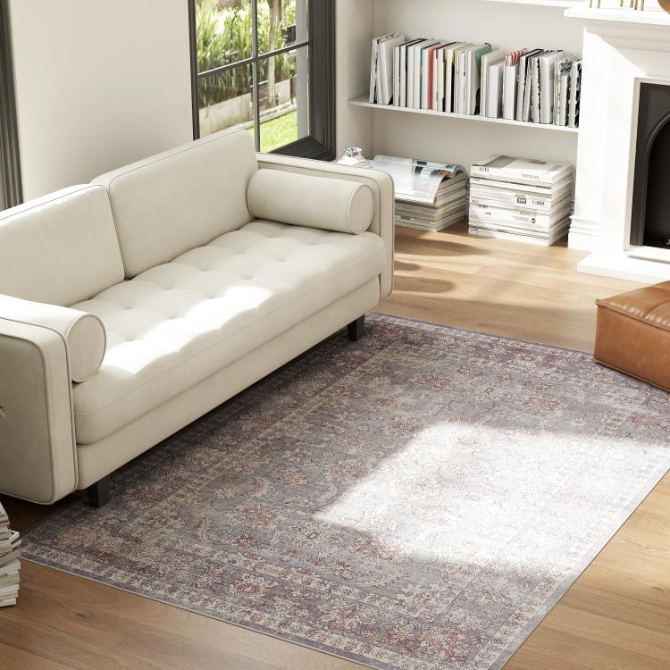 Grey and brown traditional floral area rug with scrolling motifs, centered on hardwood floor