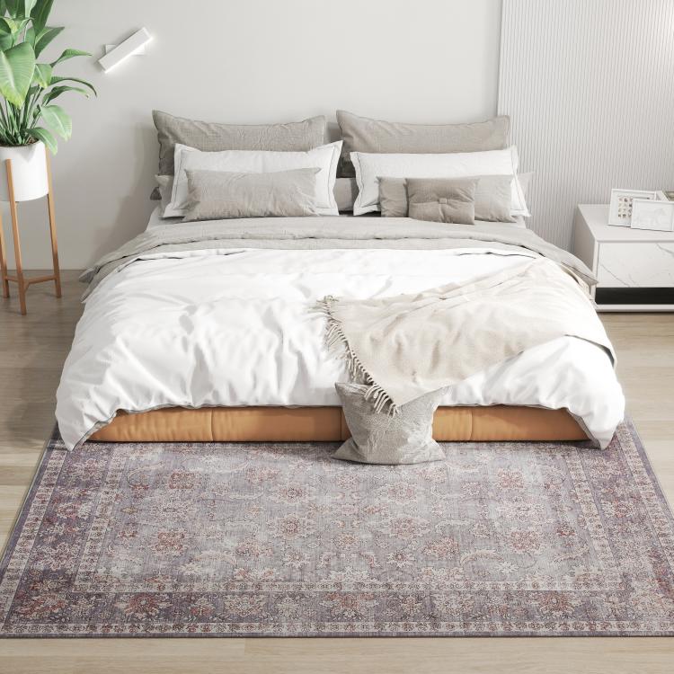 Grey and brown floral area rug with vintage medallion design under a bed