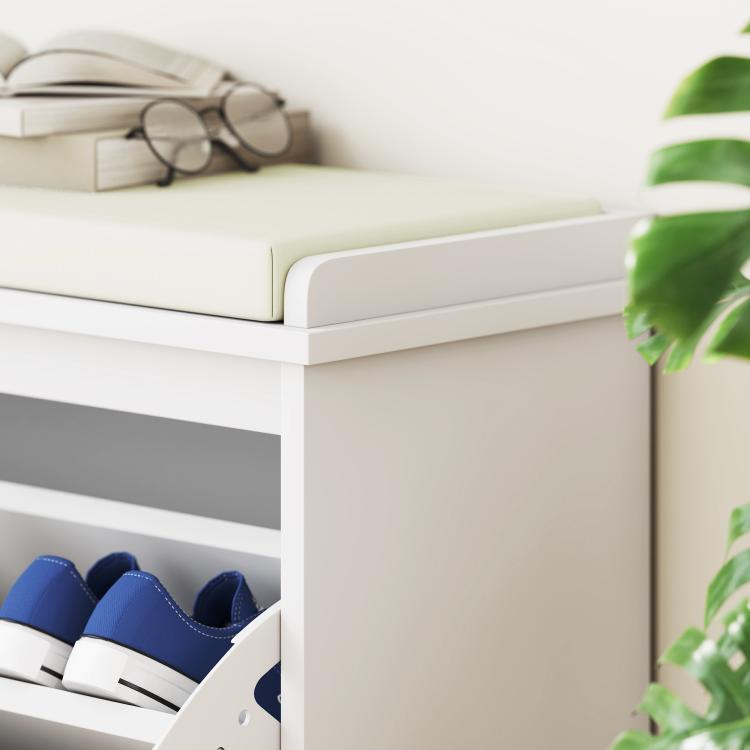 White shoe storage bench with padded seat and open shoe compartment with blue shoes