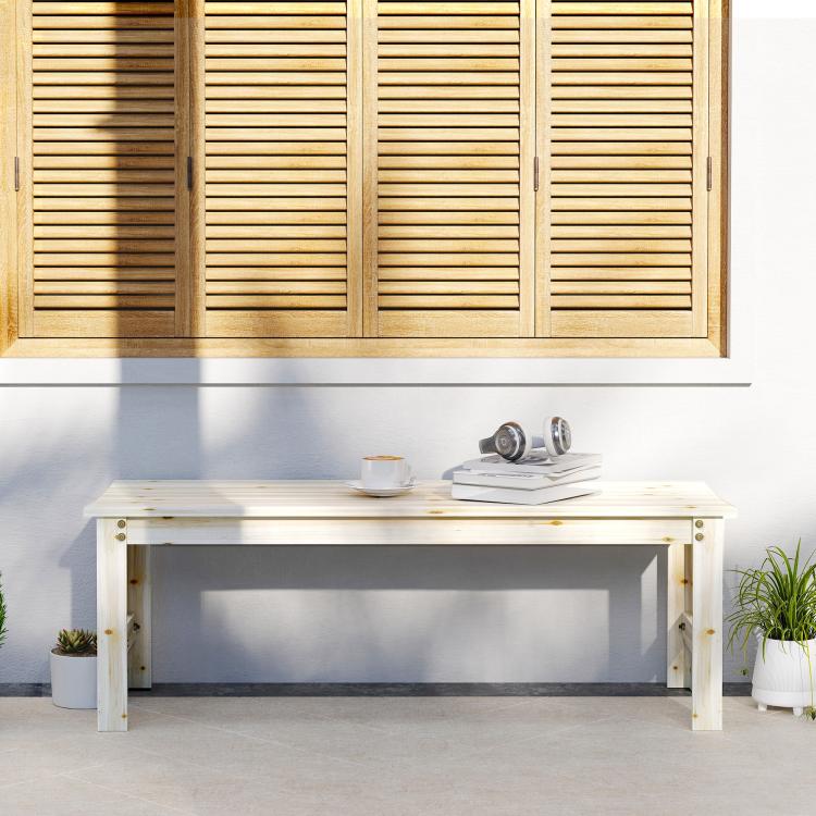 Light wood backless bench with slatted seat and four legs on patio flooring